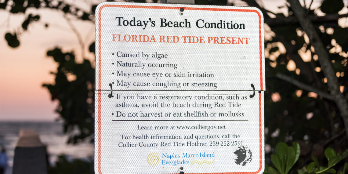 A sign warns of red tide off the coast near Naples. (iStockphoto image)