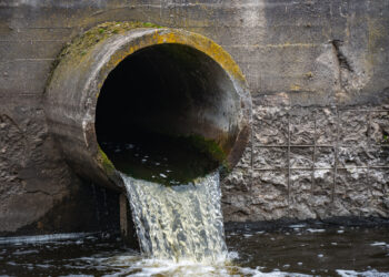 Dirty water flows from a pipe into a river. (iStockphoto image)
