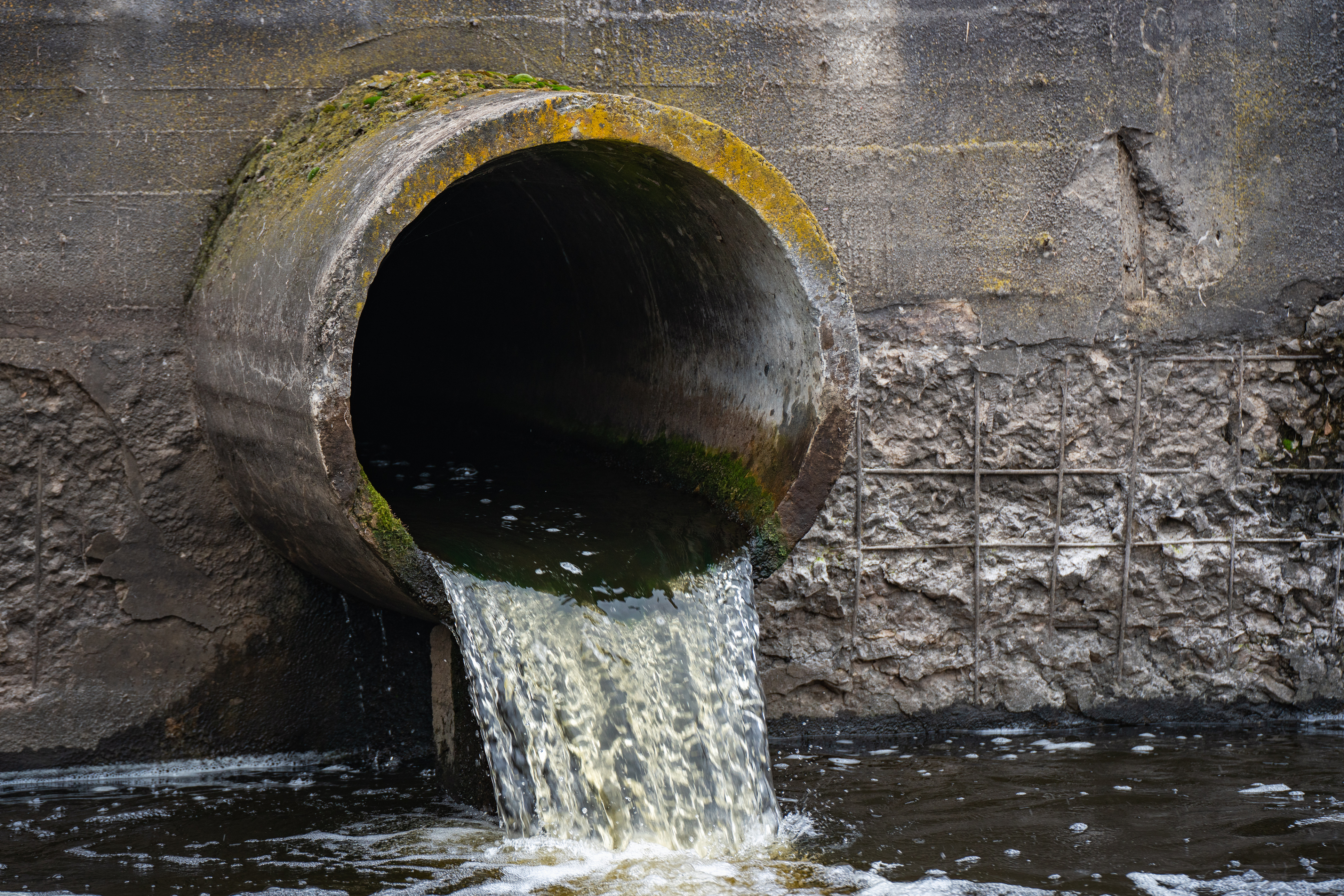 Dirty water flows from a pipe into a river. (iStockphoto image)