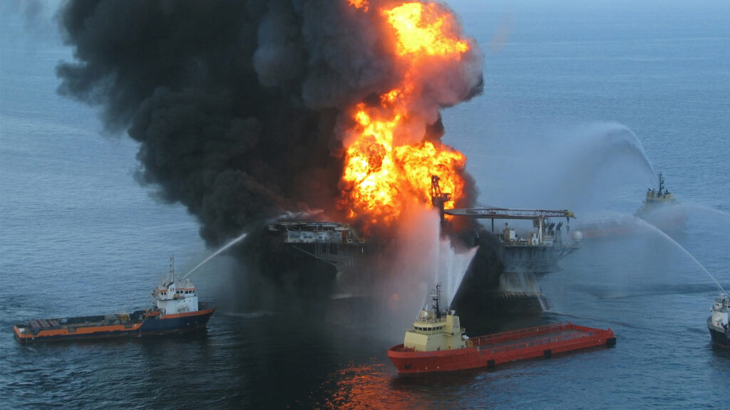 A Coast Guard rescue helicopter and crew document the fire aboard the mobile offshore drilling unit Deepwater Horizon on April 20, 2010. (US Coast Guard, via Wikimedia Commons)