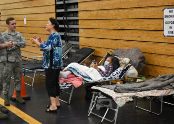 Florida Air National Guardsmen assist citizens at a special needs shelter at Atlantic Coast High School in Jacksonville in 2017, as part of the response to Hurricane Irma. (Master Sgt. William Buchanan/Florida National Guard Public Affairs Office, via Wikimedia Commons)