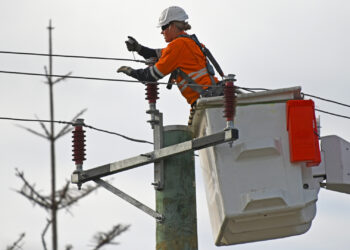 An utility worker fixes a power line. (iStock image)