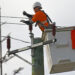 An utility worker fixes a power line. (iStock image)