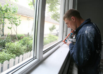 Caulk is applied to a window as part of a home refurbishment project. (USMC, via Wikimedia Commons)