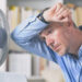 A man sweats due to the heat and tries to cool off by a fan. (iStock image)