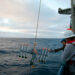 Researchers onboard the R/V Atlantis collect a sediment trap during a 2019 research cruise. Sediment traps collect particles falling toward the seafloor. Analyzing their contents helped Stukel and his research team to quantify carbon sequestration from various sources in the California Current Ecosystem. (Photo courtesy of Michael Stukel)