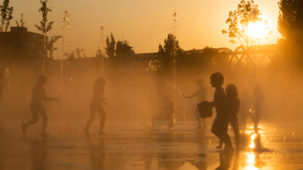 Children get relief from a heat wave in the jets of a fountain. (iStock image)