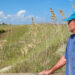 Alan Robertson looks out over the dunes on Tybee Island, Georgia. He is a consultant who helped the city acquire grant money to repair the dunes. (Grist/Emily Jones)