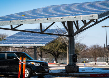 An electric vehicle charging by solar panels (iStock image)