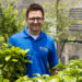 University of Florida researcher Felipe Ferrao in a Gainesville campus greenhouse with young coffee plants (in foreground). (Photo by Cat Wofford, UF/IFAS)