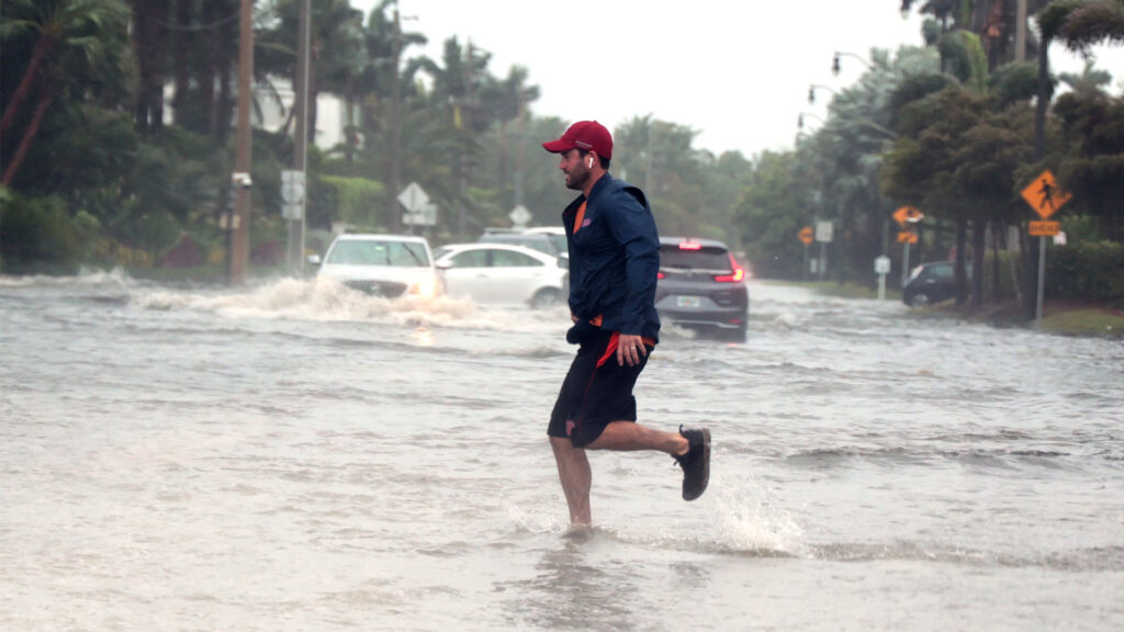 A man jogs through flooded roads in the Palm Beach area as Hurricane Nicole nears the Florida coast. (iStock image)