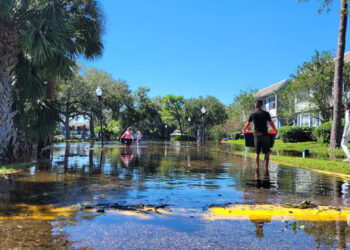 Hurricane Ian flooding victims carrying their belongings in Orlando (iStock image)