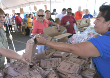 Ready-to-eat meals are distributed at a recovery center after Hurricane Katrina. (Andrea Booher, Public domain, via Wikimedia Commons)