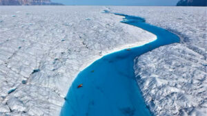 Richard Bates and Alun Hubbard kayak a meltwater stream on Greenland’s Petermann Glacier, towing an ice radar that reveals it’s riddled with fractures. (Nick Cobbing)