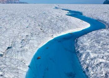 Richard Bates and Alun Hubbard kayak a meltwater stream on Greenland’s Petermann Glacier, towing an ice radar that reveals it’s riddled with fractures. (Nick Cobbing)