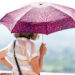 A woman holds an umbrella to block the sun. (iStock image)