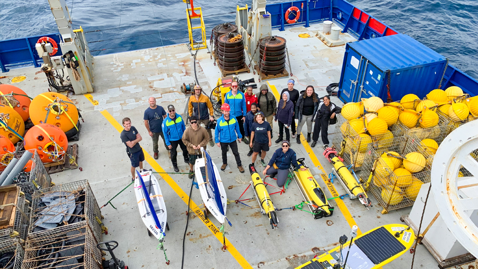 Crew members, surrounded by some of the instruments used to take ocean readings, stand on deck of the R/V Roger Revelle. (Image courtesy of Lisa Beal)