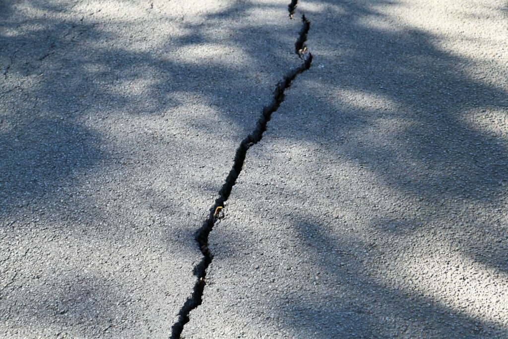 Streets crack under heat because higher temperatures create more space between vibrating molecules, causing the material to expand and deform. (Frank Vincentz, CC BY-SA 3.0, via Wikimedia Commons)