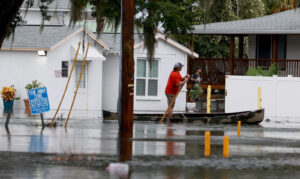 A person canoes through flooded streets in Tarpon Springs after Hurricane Idalia passed offshore on Aug. 30. (Joe Raedle/Getty Images via Grist)