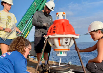 Graduate students Rachel Sampson and Paloma Cartwright, and undergraduate oceanography student Allie Cook, work with mooring technician Eduardo Jardim to prepare a CPIES monitoring device for deployment. (Photo courtesy of Lisa Beal)