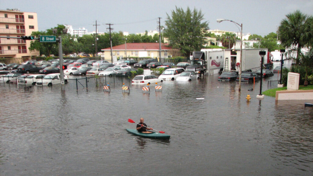 A kayak in the flooded streets of Miami Beach (Maxstrz on Flickr, CC BY 2.0, via Wikimedia Commons)