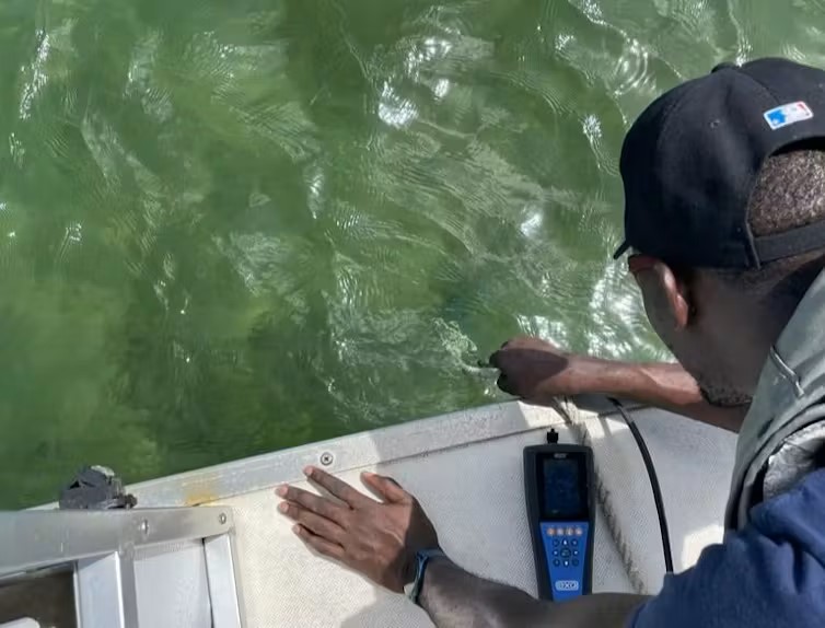 Olutobi Daniel Ogunbiyi, an author of this article and lead author of the study, takes water samples in Biscayne Bay. (CC BY-ND)