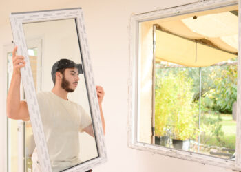 A worker installs an energy-efficient window. (iStock image)