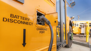 An electric school bus plugged in at a charging station (iStock image)