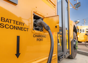 An electric school bus plugged in at a charging station (iStock image)