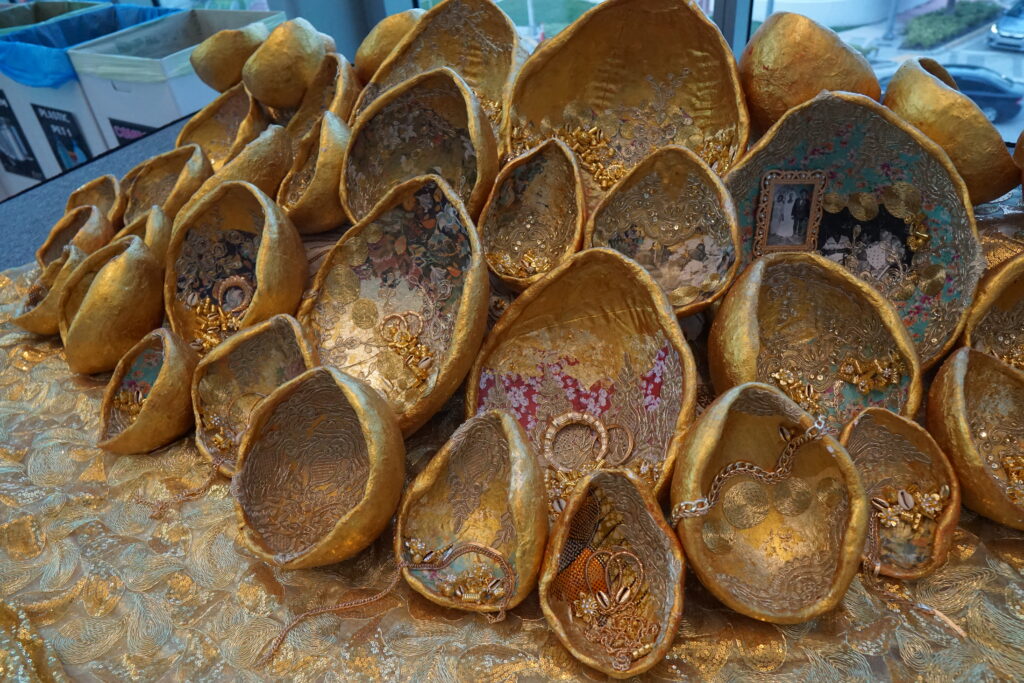 "Let it Linger" by Loni Johnson: Sculptures of gourds are painted gold, and ornamented with photo collages of family members, cowry shells, beads, bangles, earrings and natural material. (Naomi von Bose/FAU CES)