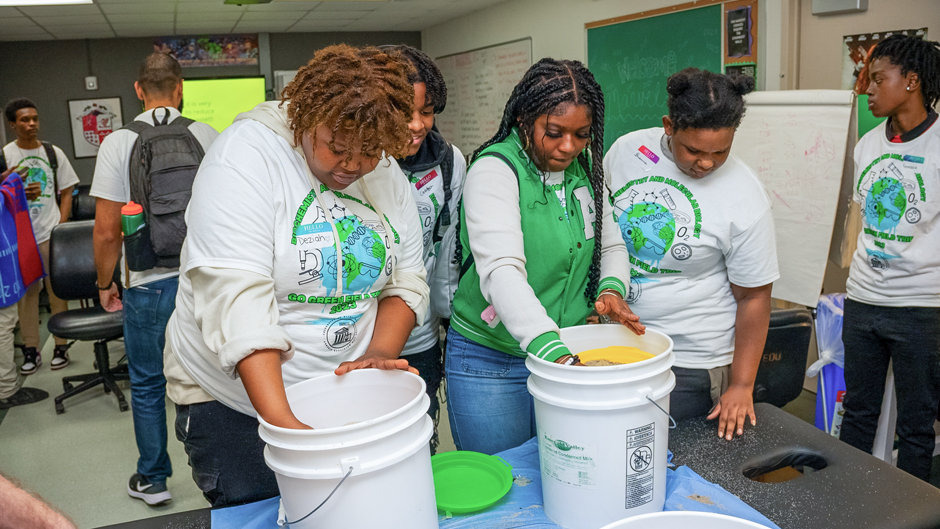 Edison High School students separate tiny particles of plastic from beach sand as part of an exercise on how microplastics enter the environment and food chain. (Daniel Menendez/University of Miami)