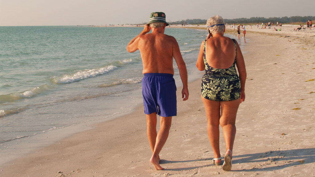 An elderly couple walks down the beach in Florida (iStock image)
