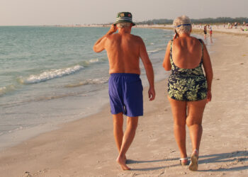 An elderly couple walks down the beach in Florida (iStock image)