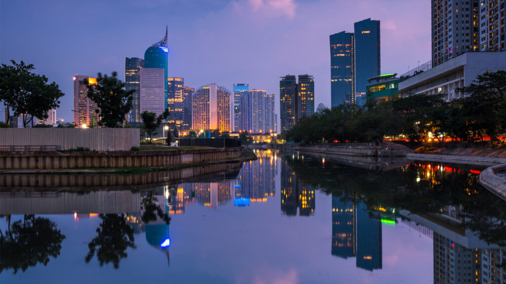 Office buildings reflected in the water in Jakarta, Indonesia. Indonesia is moving its capital 800 miles from Jakarta to Nusantara in large part because Jakarta is sinking to groundwater extraction. (iStock image)
