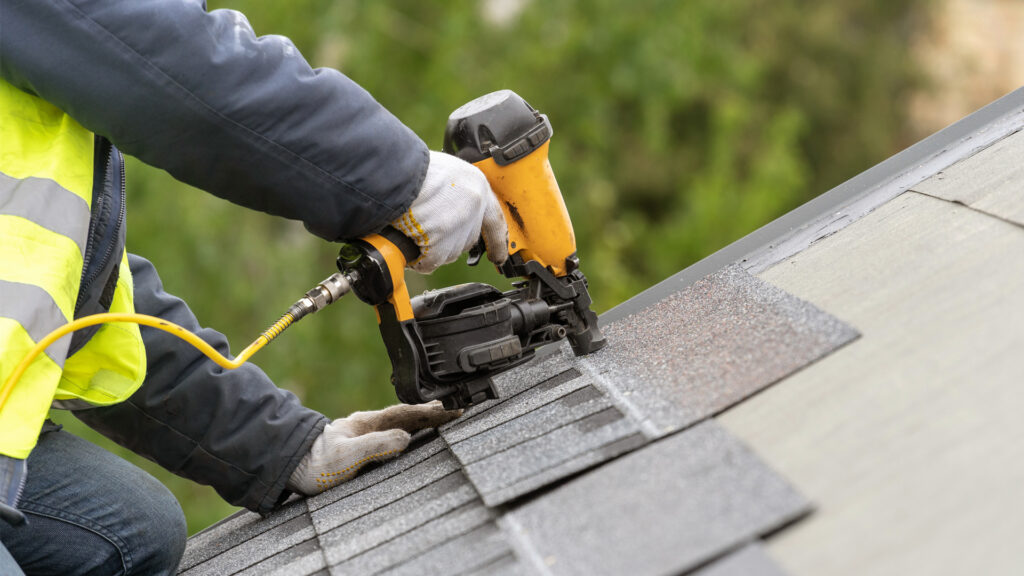 A worker installs a roof on a home (iStock image)