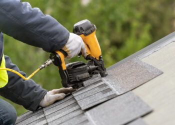 A worker installs a roof on a home (iStock image)