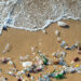 A wave pushes plastic pollution on a beach. (iStock image)