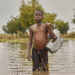 A boy crosses a flooded area, that was a farm before the flood, in Nigeria. (Sadiq Mustapha, CC BY-SA 4.0, via Wikimedia Commons)