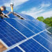 A worker installs solar panels on a rooftop (IStock image)