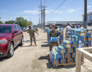 A National Guard soldier takes water to a person's car in Jackson, Mississippi, in 2022 as the city faced a water crisis. (U.S. Army National Guard photo by Staff Sgt. Connie Jones)