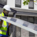 A worker lifts a solar panel. (iStock image)