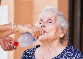 An elderly woman is given water (iStock image)
