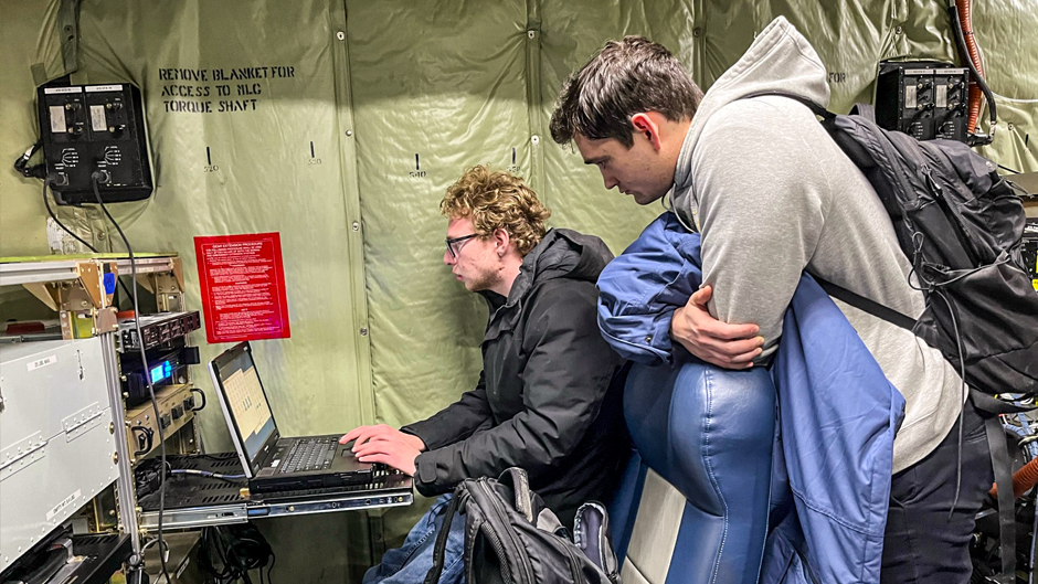 Rosenstiel School graduate students Sam Ephraim, seated, and Tyler Tatro examine data collected from instruments aboard the C-130. (Photo courtesy of Paquita Zuidema and Sam Ephraim)
