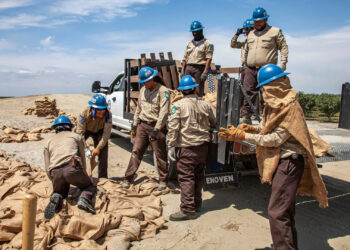 Members of the California Conservation Corps, which has open positions with the American Climate Corps, build a levee at California's Tulare Lake in 2023. (Citizen of the Planet/UCG/Universal Images Group/Getty Images via Grist)