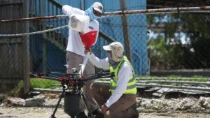 Workers from the Florida Keys’ mosquito-control department load a drone to spread BTI larvicide in an effort to eradicate dengue-carrying mosquitos on July 8, 2020, on Key Largo. (Joe Raedle/Getty Images via Grist)