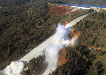 An aerial photo of the damaged spillway of the Oroville Dam and an eroded hillside in 2017. (William Croyle, California Department of Water Resources, Public domain, via Wikimedia Commons)
