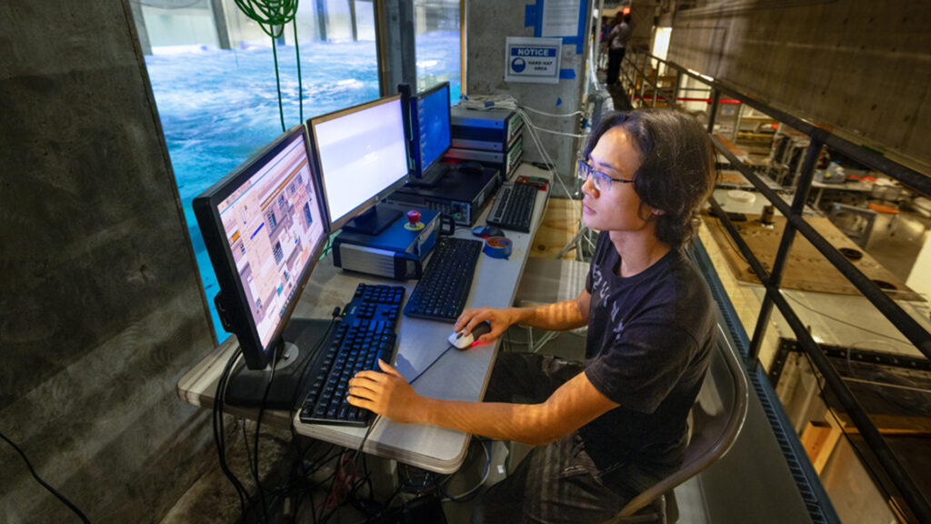 Peisen Tan conducts laboratory experiments with Category 4 hurricane-force winds blown over mechanically generated waves. (Photo: Joshua Prezant/University of Miami)