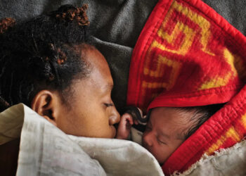 A woman sleeps with her baby in the maternity ward of a hospital in Goroka in the Eastern Highlands Province of Papua New Guinea in 2009. (Jason South/Fairfax Media/Getty Images via Grist)