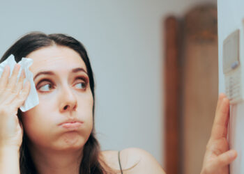 A woman adjusts her thermostat due to the heat (iStock image)