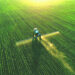 A tractor spreads fertilizer on a field. Fertilizer is a leading source of emissions of nitrous oxide, a planet-warming greenhouse gas. (iStock image)